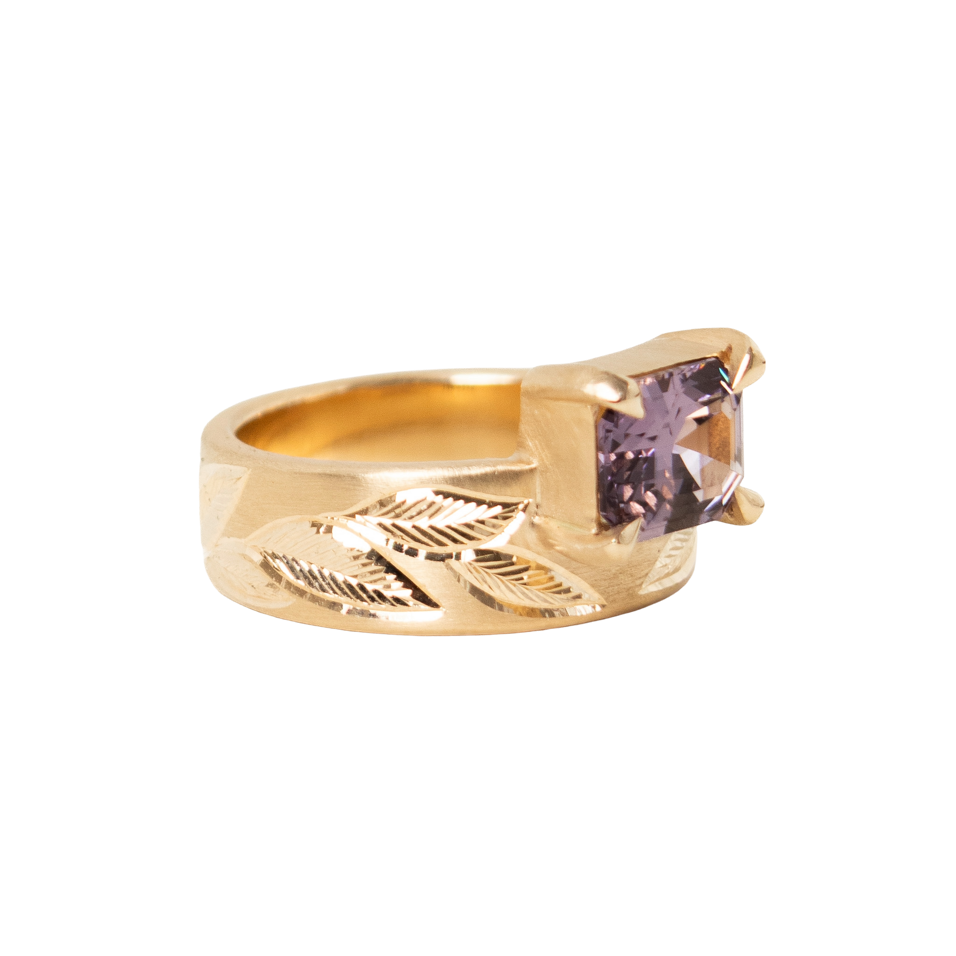 A 14k yellow gold ring featuring a rectangular emerald-cut light purple sapphire set against a plain white background.