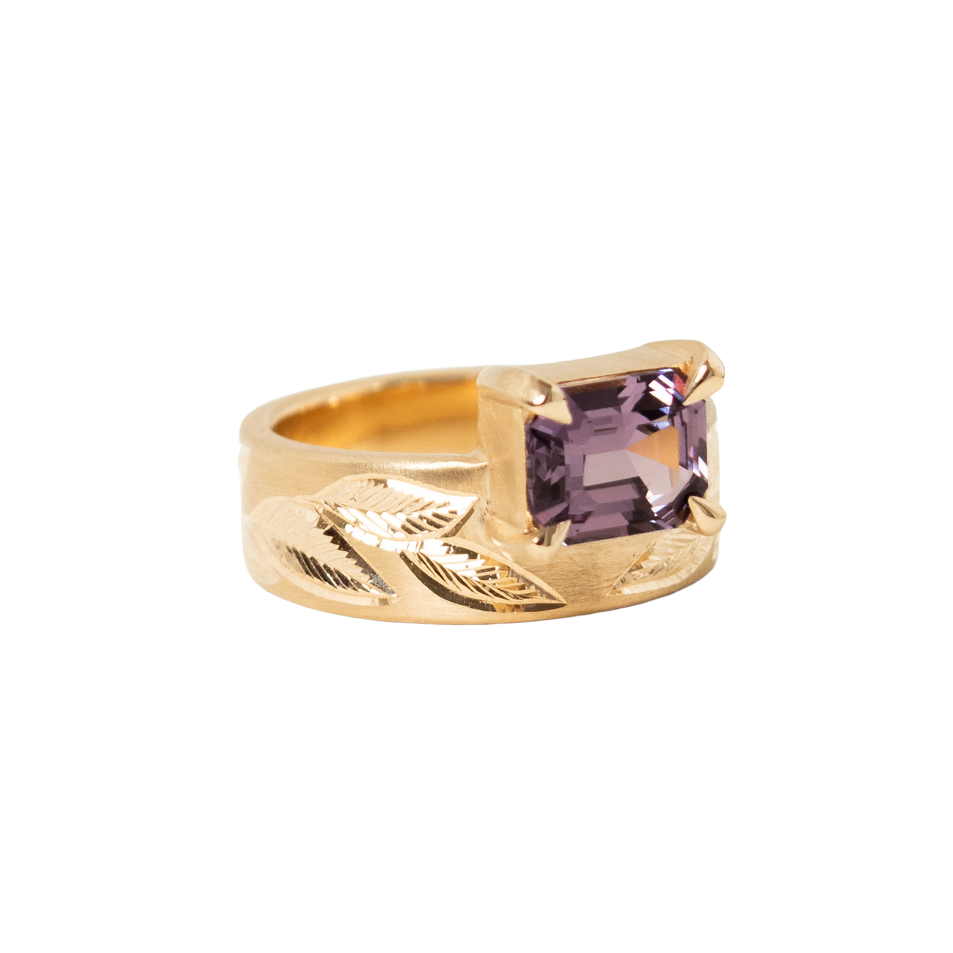A 14k yellow gold ring featuring a rectangular emerald-cut light purple sapphire set against a plain white background.