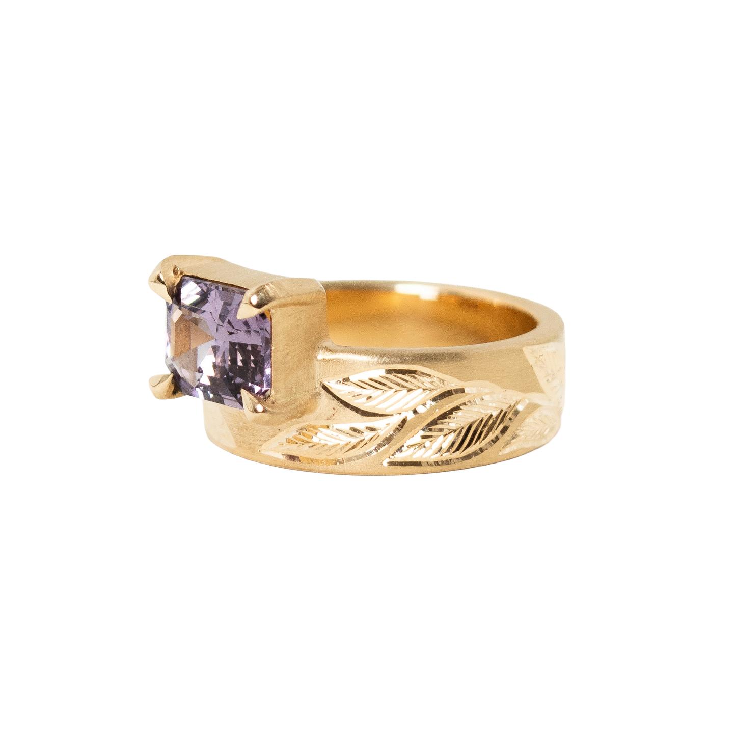 A 14k yellow gold ring featuring a rectangular emerald-cut light purple sapphire set against a plain white background.